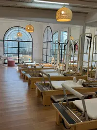 Sala luminosa con equipos de Pilates Reformer.